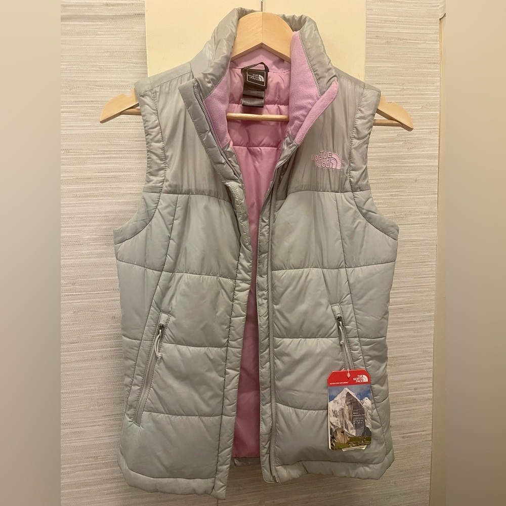 SOLD The North Face insulated vest in gray with tags attached.